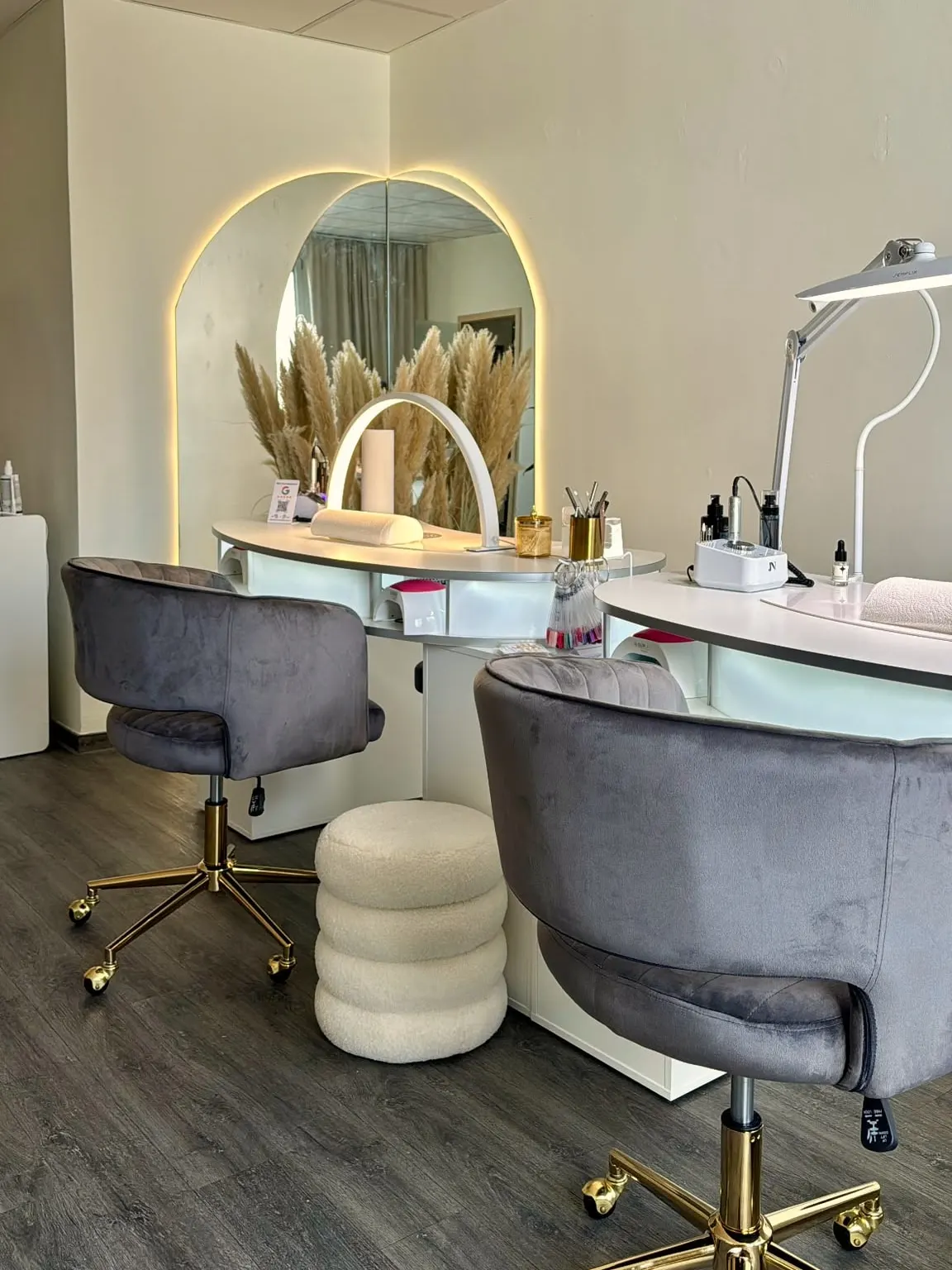 Zwei Arbeitsplätze mit Samtsesseln und Bogenspiegel im Studio von Lumara Aesthetica, Nagelstudio Rostock